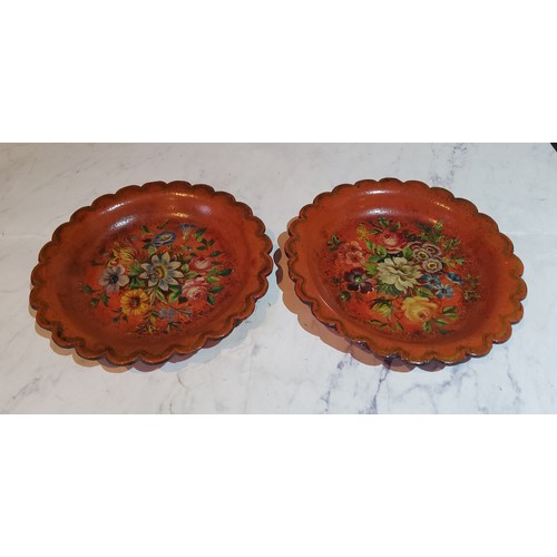 109 - A pair of 19th century shaped circular papier mache wine coasters, painted with flowers, 16.5cm diam... 