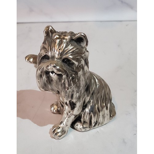 129 - A silver model of a West Highland Terrier, paw raised, 6cm high, filled