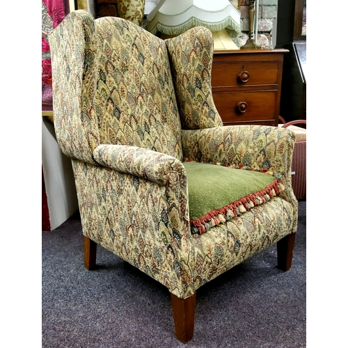 613 - A Howard & Sons style wingback armchair, heavy gauge tapestry upholstery, mahogany feet