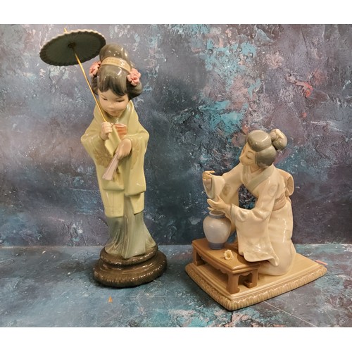 2 - A Lladro figure of a Geisha, standing holding a fan, 32cm high, printed mark;  another, of a la... 