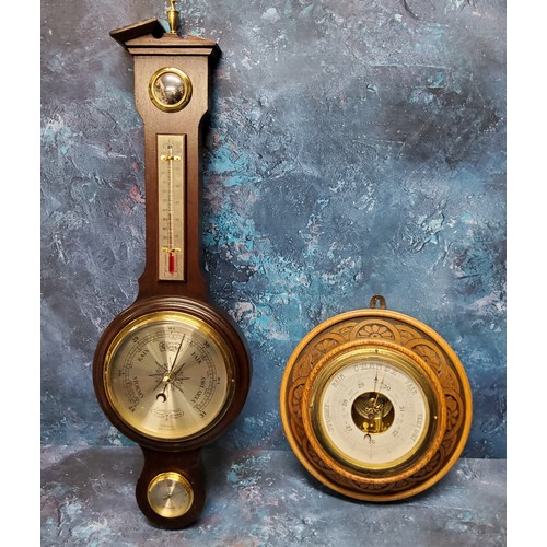 83 - An early 20th century oak barometer, carved with demi-flowers, 23cm diam;  another, wheel barometer,... 