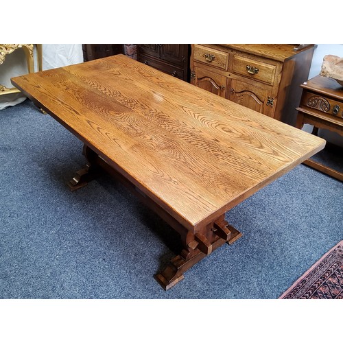 516 - An English oak and elm trestle dining table, well figured top, pierced supports, twin central refect... 