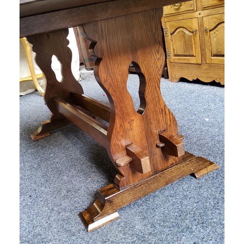 516 - An English oak and elm trestle dining table, well figured top, pierced supports, twin central refect... 