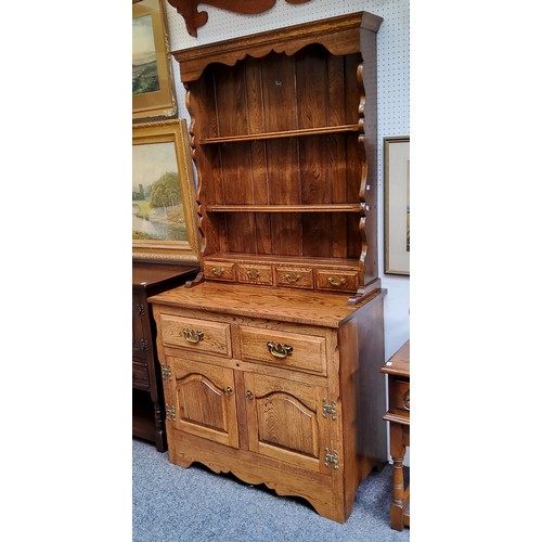 520 - A bespoke 20th century oak dresser, shaped apron above two shelves and four spice drawers, the proje... 