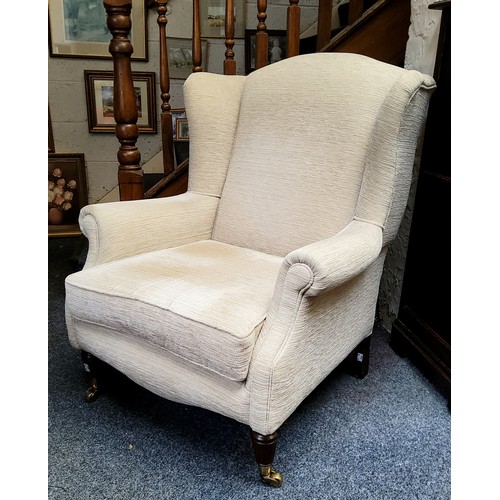 533 - A Victorian style wingback armchair, tapered legs, upholstered in cream