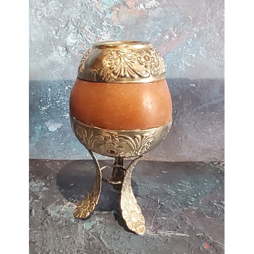 184 - A South American silver coloured metal mounted calabash gourd mate cup, loft legs, 14cm high