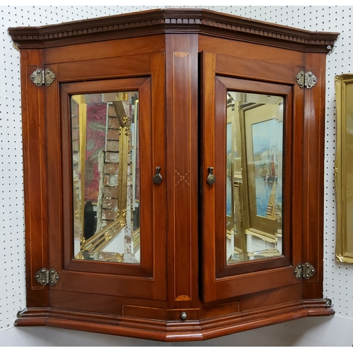 433 - An Edwardian Sheraton Revival canted corner cupboard, dental cornice above mirror panelled doors wit... 