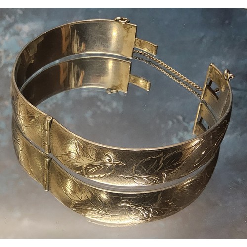 374 - A silver hinged bangle, engraved & chased with foliage, clasp faulty, Harrod's Stores Ltd, Birmi... 