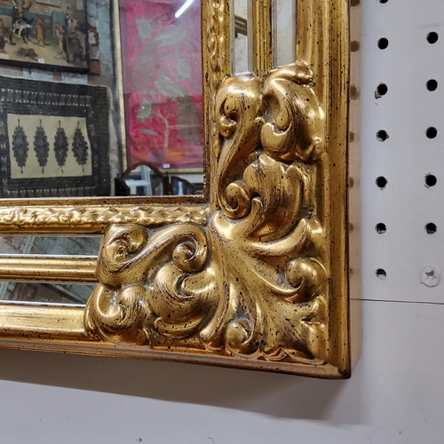 549 - A large decorative gilt over mantel mirror, acanthus capped to frame with double 'antique' foxed mir... 