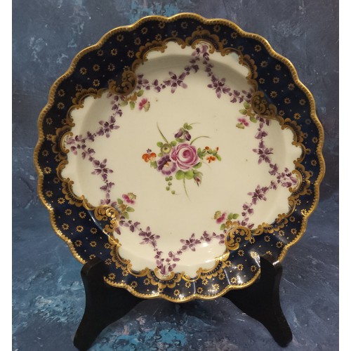 227 - A Worcester shaped circular plate, painted with a central bouquet of flowers and purple swags the we... 