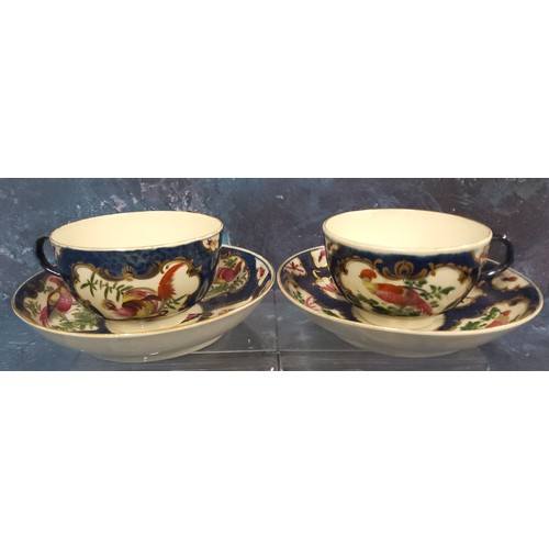 228 - A pair of Worcester blue scale  teacups and saucers, painted with alternating cartouche and vase sha... 