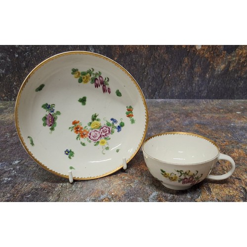 174 - A Bristol teacup and saucer,  painted with colourful summer flowers, gilt dentil rim, c.1780