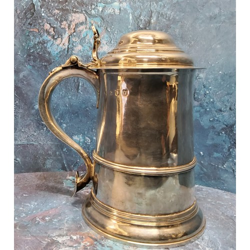 36 - A George II silver spreading cylindrical tankard, hinged domed cover, scroll handle with heart termi... 