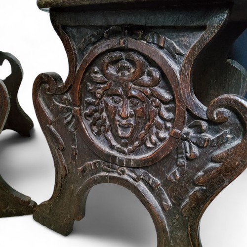 655 - An unusual pair of '17th Century' Continental sgabello hall chairs, the back profusely carved with s... 