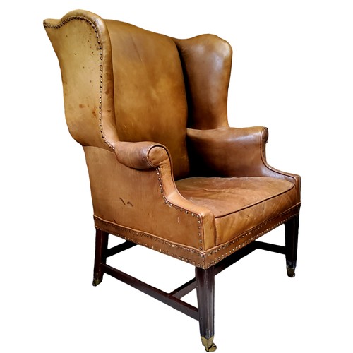 656 - A George III mahogany wingback armchair, c1780, in close nailed leather upholstery, seat height 47cm... 