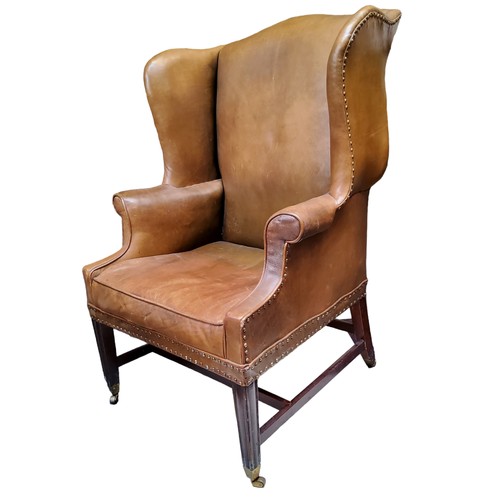 656 - A George III mahogany wingback armchair, c1780, in close nailed leather upholstery, seat height 47cm... 