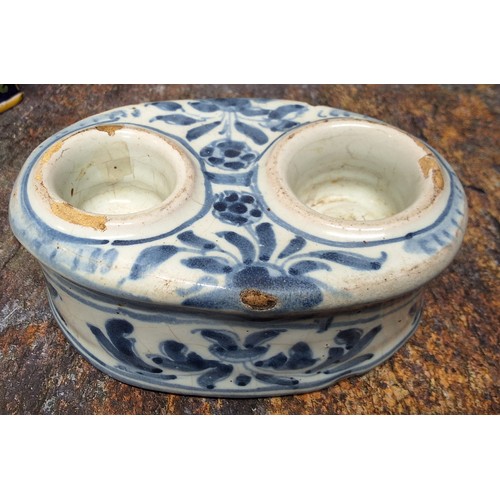 311 - A 19th century tin glazed oval inkwell, with two wells, decorated with stylised foliage in underglaz... 