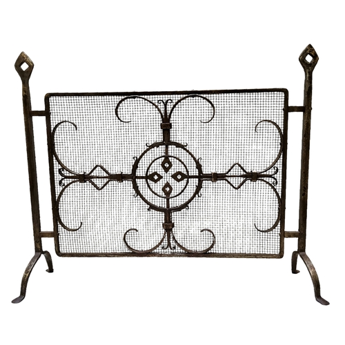 748 - An early 20th century wrought iron fire guard with a mediaeval geometric design, bold openwork iron ... 