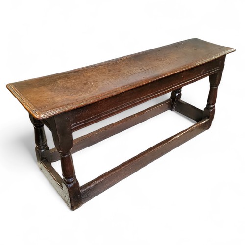 763 - An early 17th century Charles I English oak bench or long joint stool, moulded top above a deep flut... 