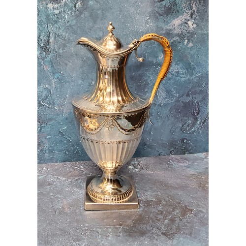 61 - A George III silver urnular hot water pot and cover, half fluted below ribbon tied swags, domed cove... 