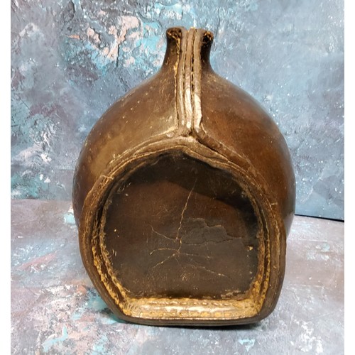 555 - A 17th/18th leather costrel, the open spout flanked by two holes for a strap handle, 24cm high, 22cm... 