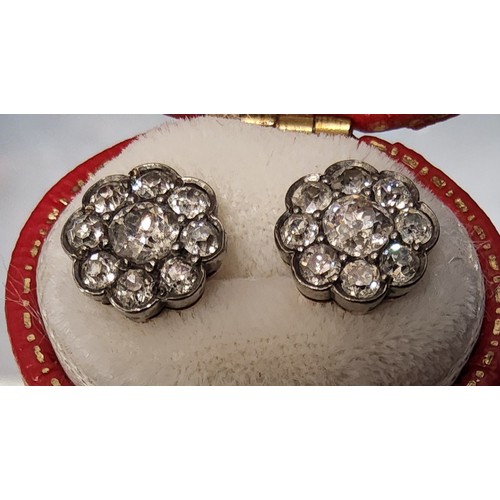 82 - A pair of 18ct gold & diamond cluster earrings, each set with a central round diamond approx. 0.... 