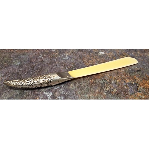 130 - A Victorian silver hafted and ivorine page turner, the haft embossed with scrolling foliage, 25cm lo... 