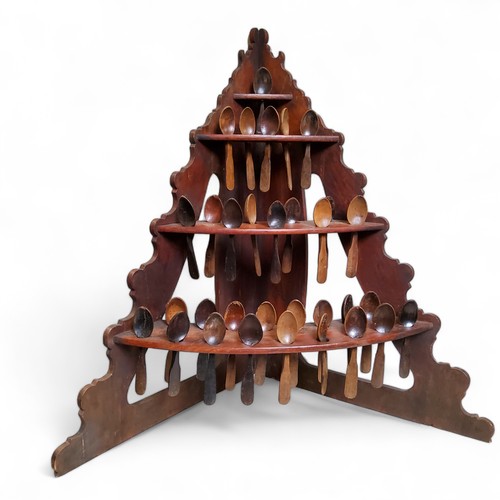 494 - An unusual 19th century farmhouse pine three tier corner spoon rack, complete with thirty-two treen ... 