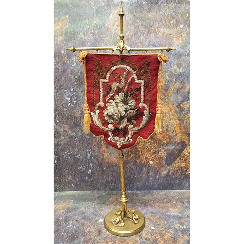 442 - A Victorian gilt brass table banner, beadwork panel,  the column cast with scrolls, triform figural ... 