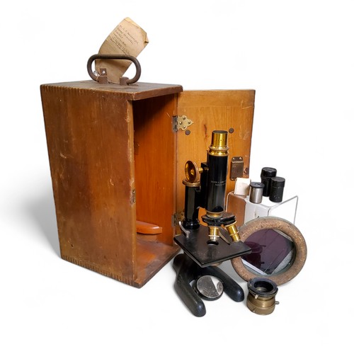 710 - An American Bausch & Lomb brass and ebonized metal microscope, with three lenses, two Spencer, B... 