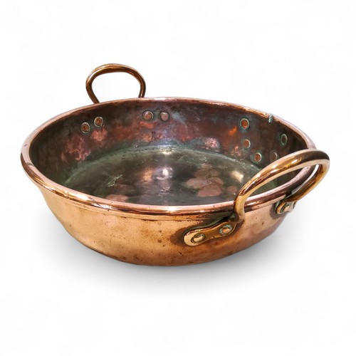 559 - A 19th century copper two handled pan, roll top, 41cm over brass handles