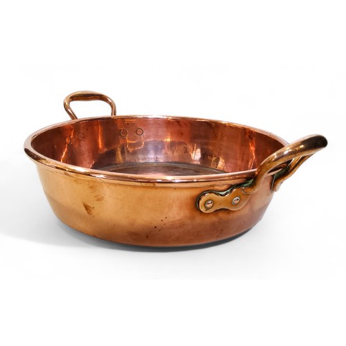 560 - A 19th century copper two handled pan, roll top, 46cm over brass handles