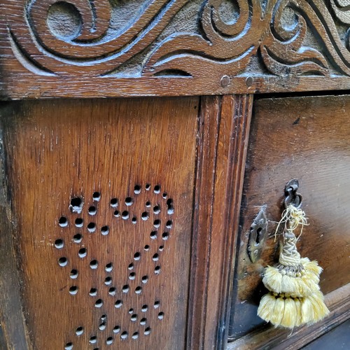 877 - A William & Mary oak livery cupboard, the carved scrolling foliate frieze above two central cupb... 