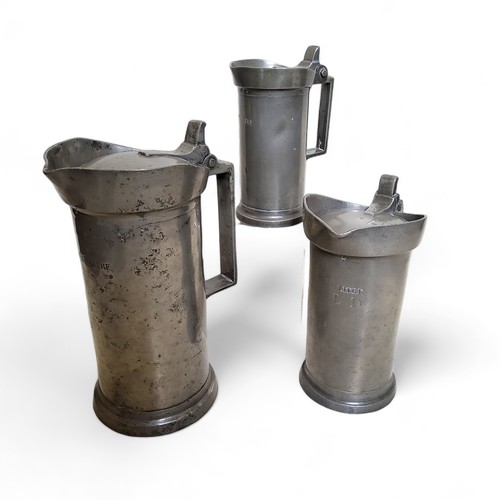 31 - A set of three graduated 19th century French pewter flagons, Double Litre - Demi-Litre,  hinged cove... 