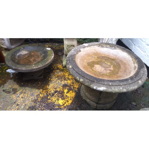 766 - A reconstituted stone pedestal bird bath, 54cm diam;  another, smaller, 43cm diam;  a tapering squar... 