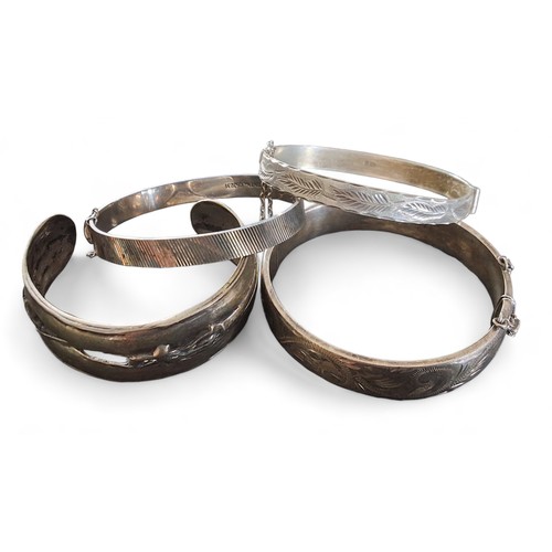 207 - A silver hinged bangle, chased and engraved with scrolls, Excalibur Jewellery Ltd, Birmingham, ... 