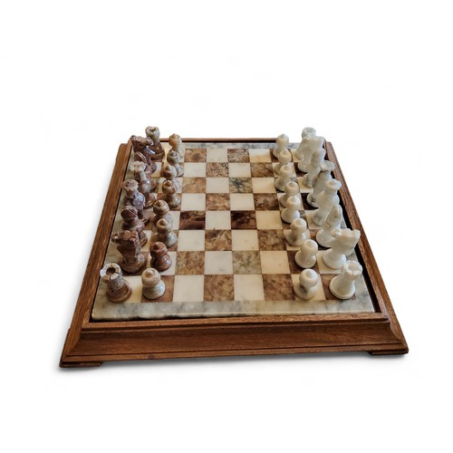 135 - An onyx chess set, travertine and white, 44cm wide