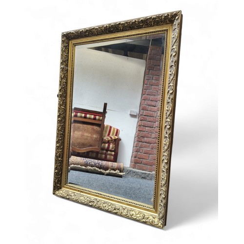 499 - A 20th century rectangular bevelled edge wall mirror, foliate gilt frame, 89cm high, 62cm wide.