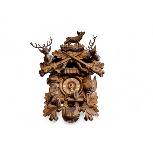 347 - A Black Forest cuckoo clock, 9cm dial applied with Roman numerals, the case carved with dead game, d... 