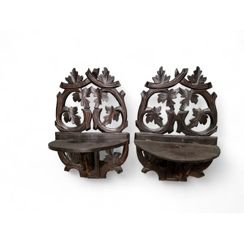 357 - A pair of early 20th century Black Forest wall brackets, carved with scrolling leaves and foliage, 3... 