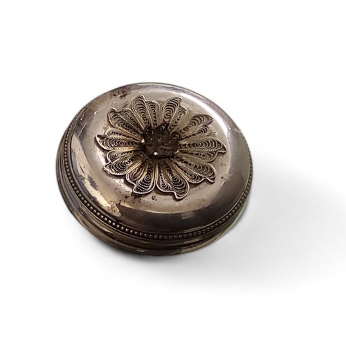 111 - A silver circular trinket box, the cover with filigree flower, 5.5cm diam, London 1986