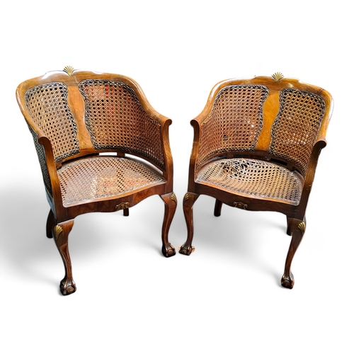 30 - A pair of 1920's walnut French Bergere tub chair, gilded scallop carved bowed back back rest, serpen... 