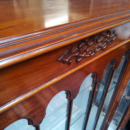 31 - A late Victorian walnut and mahogany Gothic Revival display cabinet, raised on cabriole legs termina... 