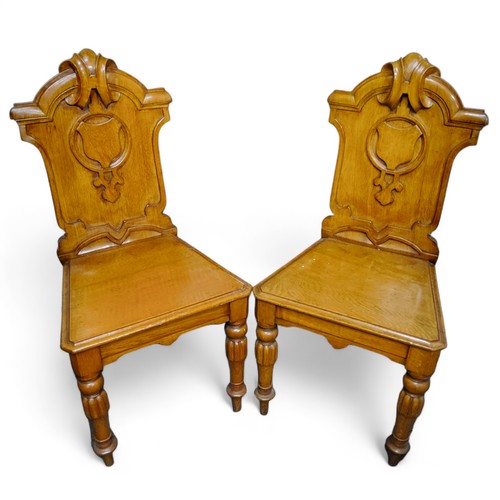 110 - A pair of Victorian oak shield back hall chairs, c.1870