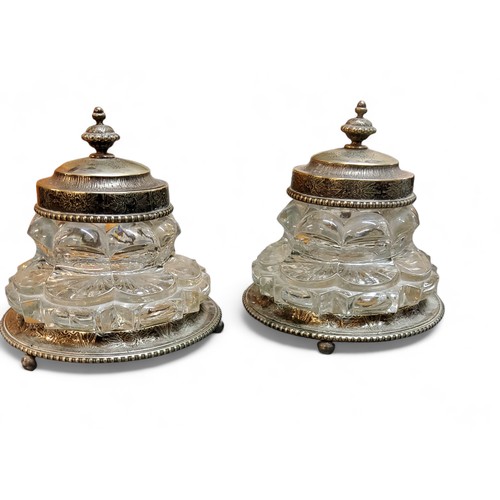 370 - A pair of Victorian plated and clear glass inkwells, hinged covers, detachable bases, 13cm high, c.1... 