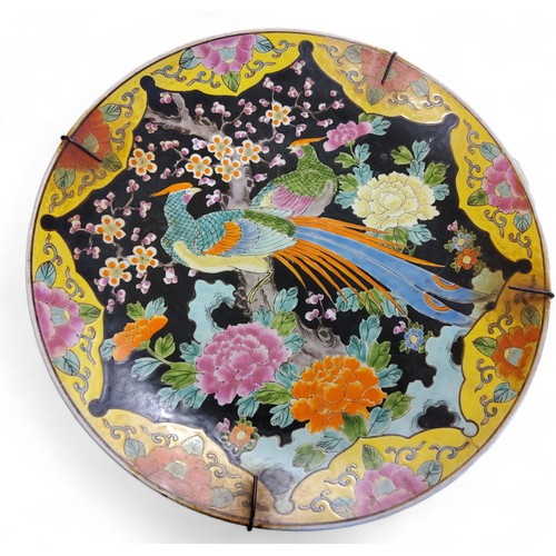 524 - A late early 20th century Japanese charger, decorated with fanciful birds and peonies, brightly deco... 