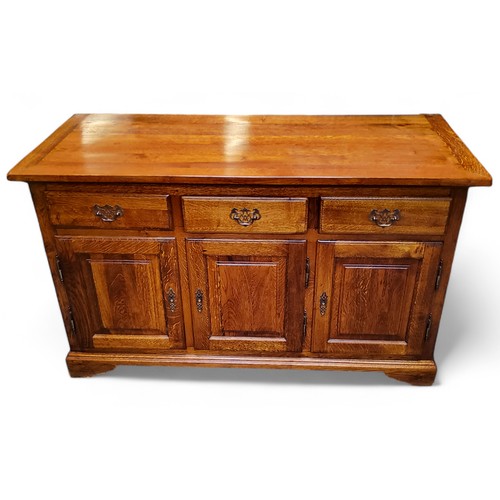 227 - A 20th century golden oak sideboard, with three short drawers above fielded panelled doors, 78cm hig... 