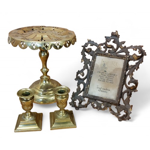 113 - A pair of brass boudouir candlesticks, the sconces embossed with husk swags, spreading square bases,... 