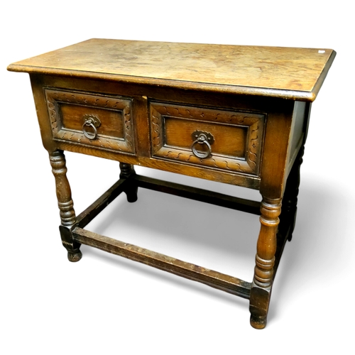 649 - An early 20th century oak hall table, two drawers to frieze, Colonial type ironwork drop loop handle... 