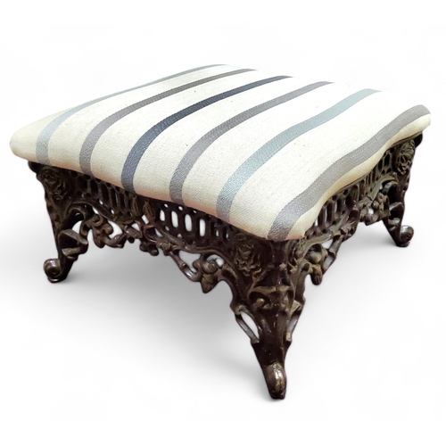 629 - A cast iron low foot stool in the manner of Coalbrookdale, pinstriped overstuffed upholstered seat, ... 